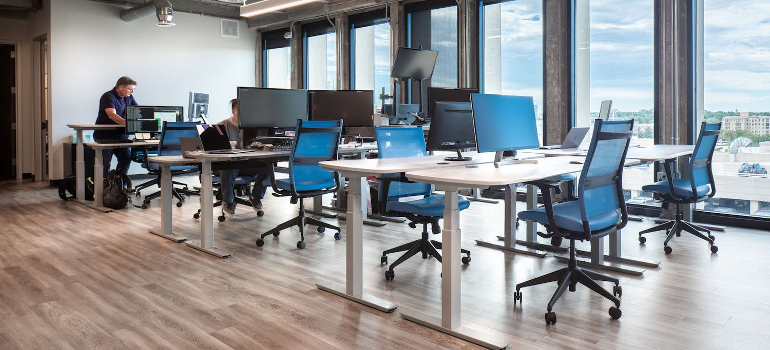 Open Workspace with standing desks with windows overlooking Cherry Creek Denver area with blue chairs - open floorplan 2021